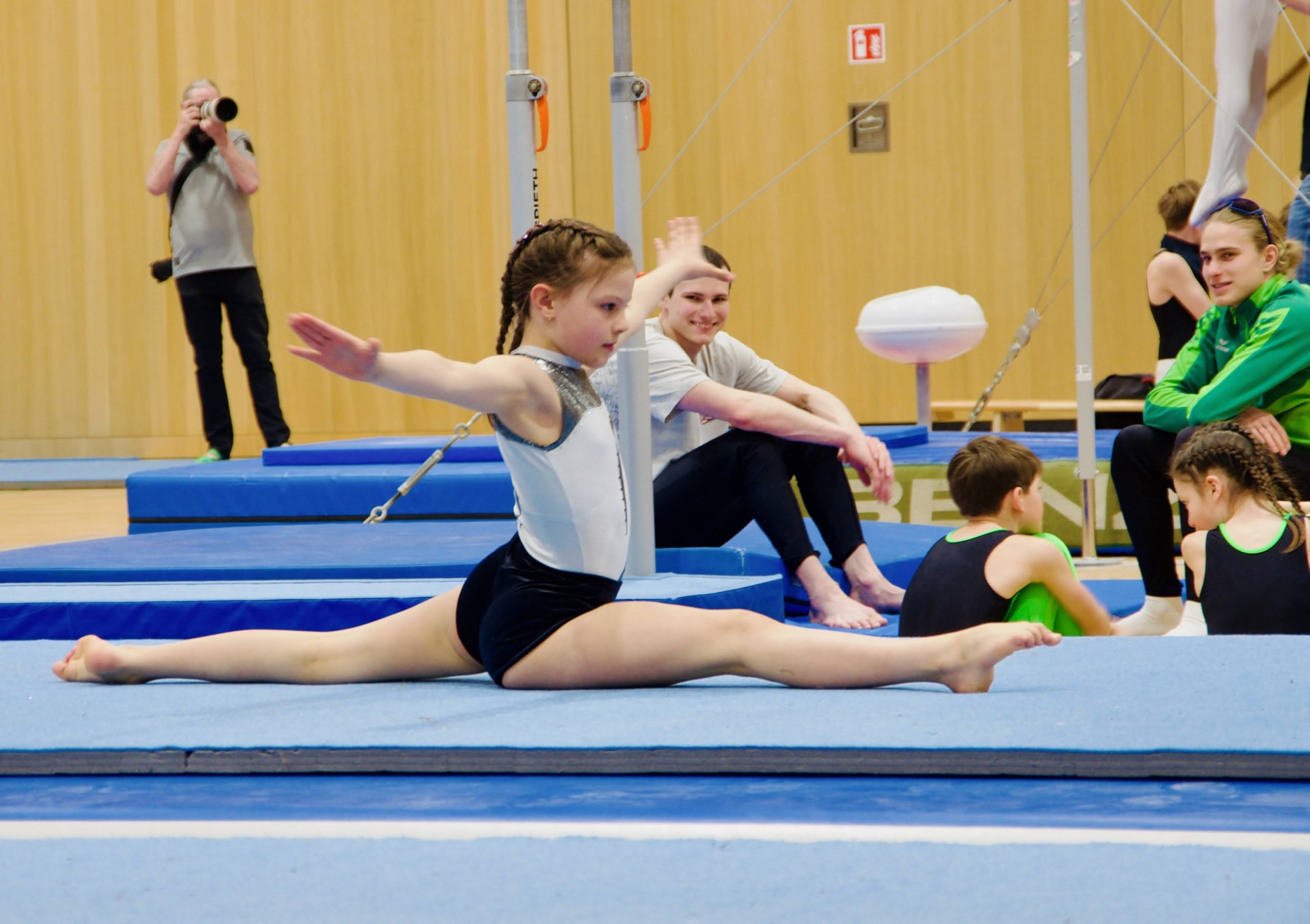 Mädchen am Boden im Seitspagat rechts mit ausgestreckten Armen